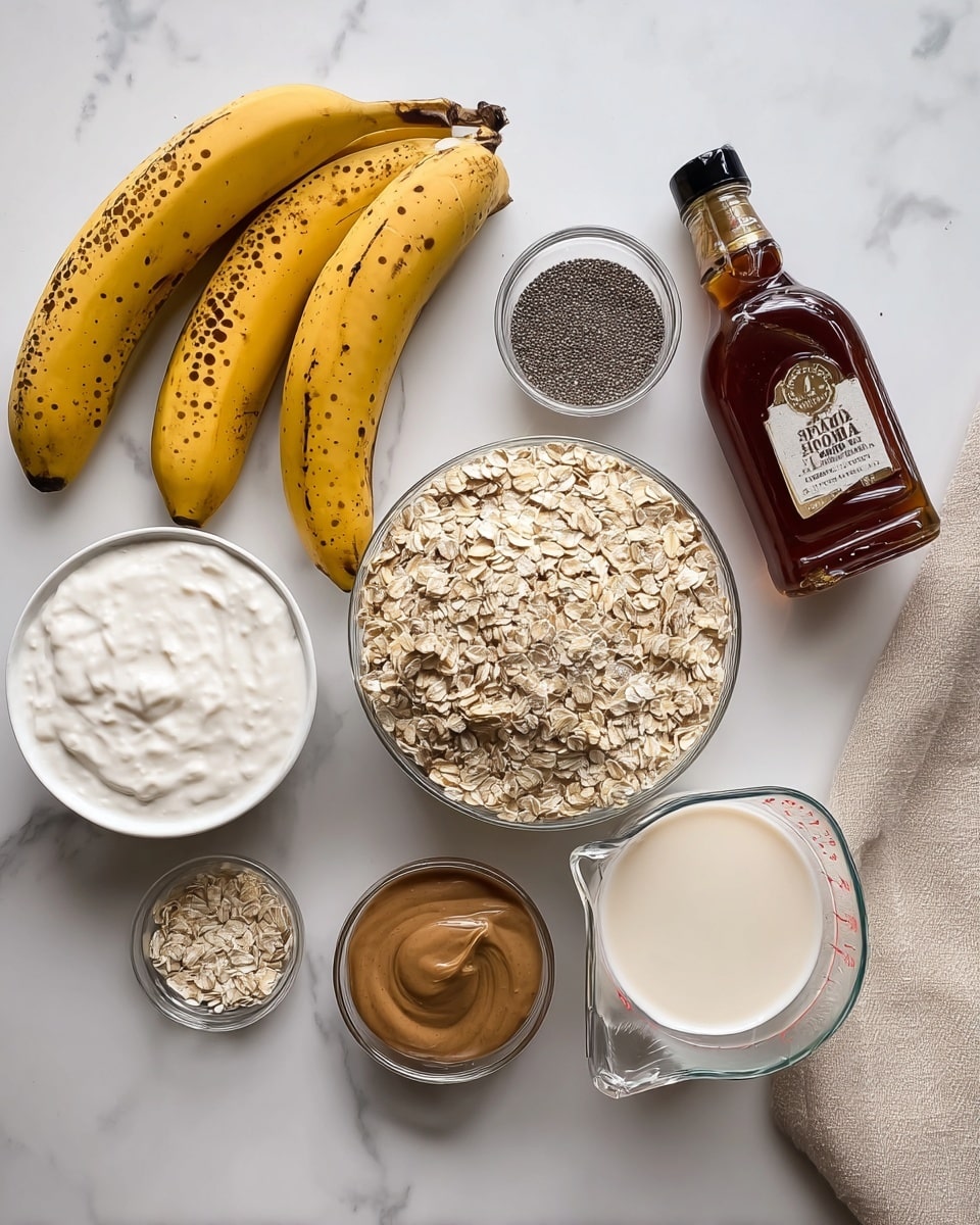 The image shows a collection of ingredients on a white marbled surface: three yellow bananas with brown spots are on the left, above a white bowl filled with a white creamy substance. Next to these is a glass container filled with light brown rolled oats, surrounded by smaller glass containers, one with tiny black chia seeds and another holding light brown powder in a half-cup measuring spoon. Below the oats is a small glass bowl with smooth brown nut butter. On the right, there's a clear measuring cup full of creamy white liquid and a bottle of dark amber maple syrup with a black cap. A beige cloth napkin is partially visible in the top right corner, and a woman's hand holding a small amber bottle of vanilla flavoring is seen at the bottom left corner. photo taken with an iphone --ar 4:5 --v 7