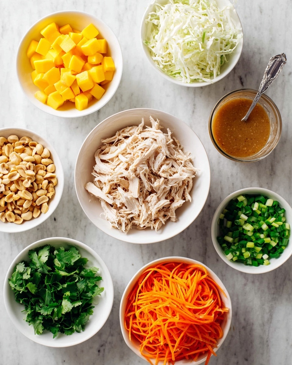 A top view shows seven white bowls arranged on a white marbled surface. In the center, a bowl is full of shredded pale chicken with a slightly fibrous texture. To the left, a bowl holds small, cubed bright yellow mango pieces. Above the chicken, a bowl contains thin, white shredded cabbage piled high. On the right, a small bowl is filled with chopped green onions, showing different shades of green. Next to it, a clear glass cup with a metal spoon holds a smooth, brown sauce. Below the chicken, a bowl contains bright, shredded orange carrots, and next to it, a bowl of finely chopped fresh green herbs, probably cilantro, adds more green color. A small bowl to the far left contains small chopped nuts in light beige tones. All bowls create a colorful, fresh, and textured display. Photo taken with an iphone --ar 4:5 --v 7