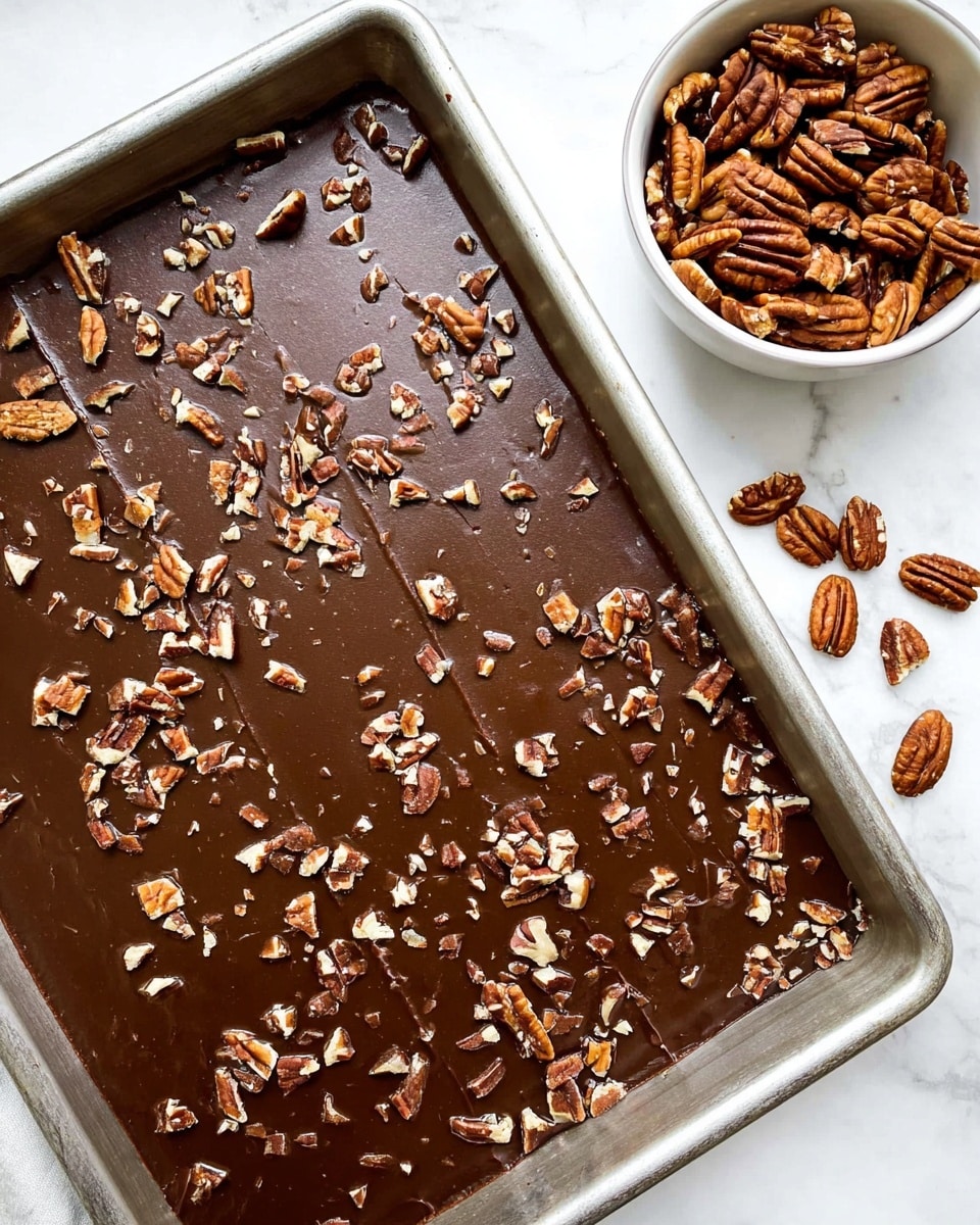 A stack of four square chocolate brownies is shown against a white marbled background. Each brownie has two visible layers: a thick, dark brown, soft cake layer on the bottom and a smooth, lighter brown glossy frosting layer on top. The top brownie has a small bite taken out of the corner, showing the dense texture inside. Small pieces of pecans are scattered on the frosting of each brownie, some whole and some broken, adding a rough texture and light brown color contrast. The brownies are stacked unevenly, creating a sense of depth and height. Photo taken with an iphone --ar 4:5 --v 7
