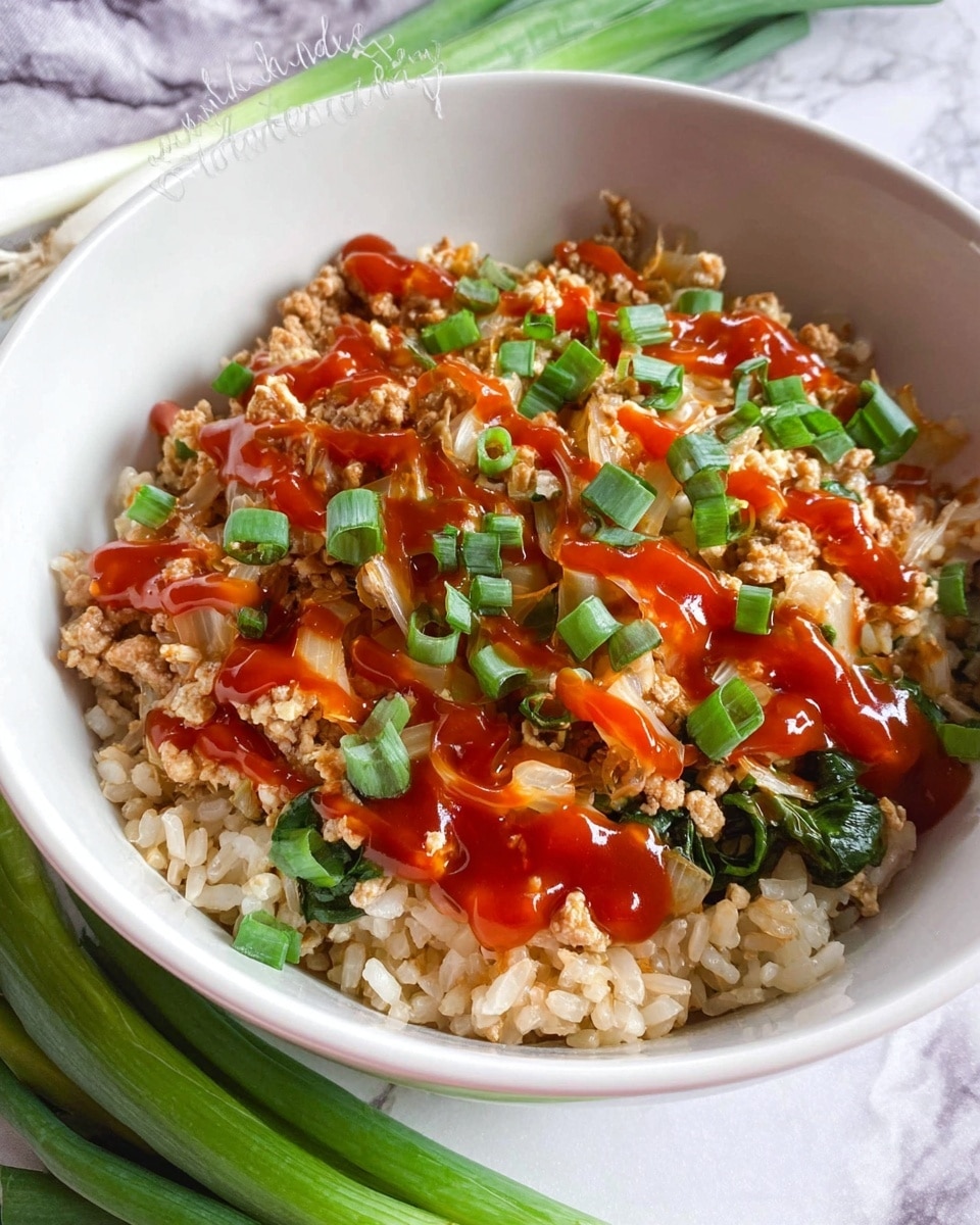 A white bowl filled with three visible layers: the bottom layer is light brown cooked rice with a soft texture, the middle layer consists of light tan cooked ground meat mixed with thin, pale yellow vegetable slices, and the top layer has bright red sauce drizzled unevenly over the dish followed by chopped dark green spring onions scattered on top. The bowl is placed on a white marbled surface with some green onions resting nearby. Photo taken with an iphone --ar 4:5 --v 7