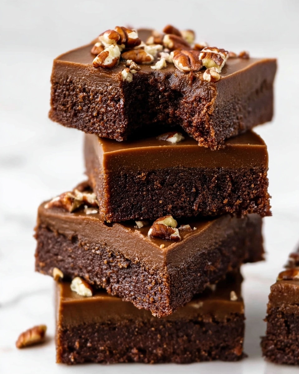A rectangular metal baking tray filled with one thick, smooth, dark brown layer of chocolate fudge, topped evenly with small and large pieces of chopped pecans scattered across its shiny surface. Near the tray, a white bowl holds whole pecans, and the tray is placed on a white marbled surface. Photo taken with an iphone --ar 4:5 --v 7