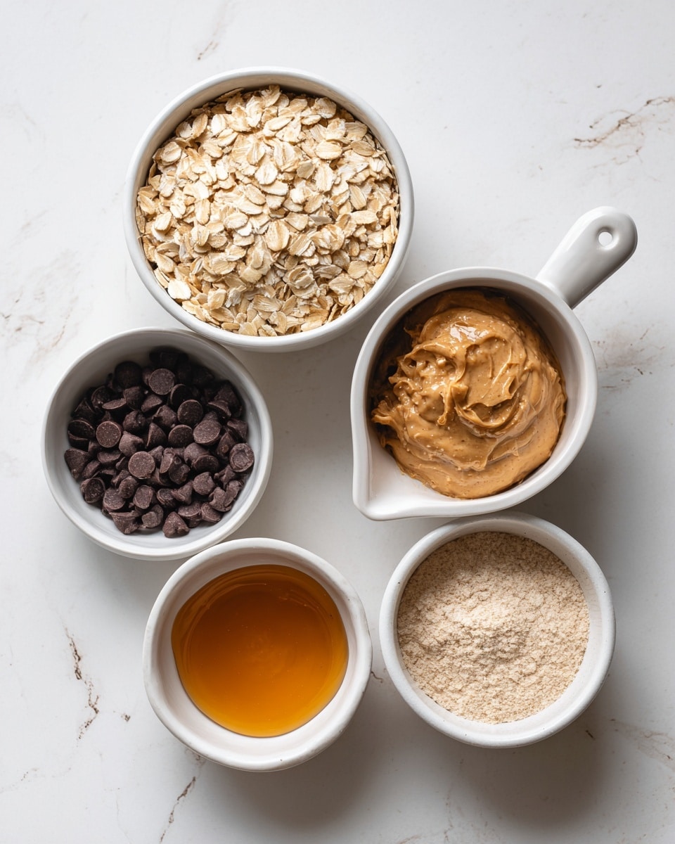Five white bowls with ingredients are placed on a white marbled surface. The top middle bowl holds pale tan old fashioned rolled oats with flat, rough texture. To the right, there is a white bowl with a handle filled with smooth, shiny, light brown natural peanut butter. Below it, a smaller white bowl contains light beige vanilla protein powder with a powdery texture. To the left, below the oats, a bowl shows dark brown chocolate chips that are small and oval. The last bowl, to the left of the oats, holds golden amber honey with a thick, glossy surface. All bowls are round except for the peanut butter bowl with a handle. Photo taken with an iphone --ar 4:5 --v 7