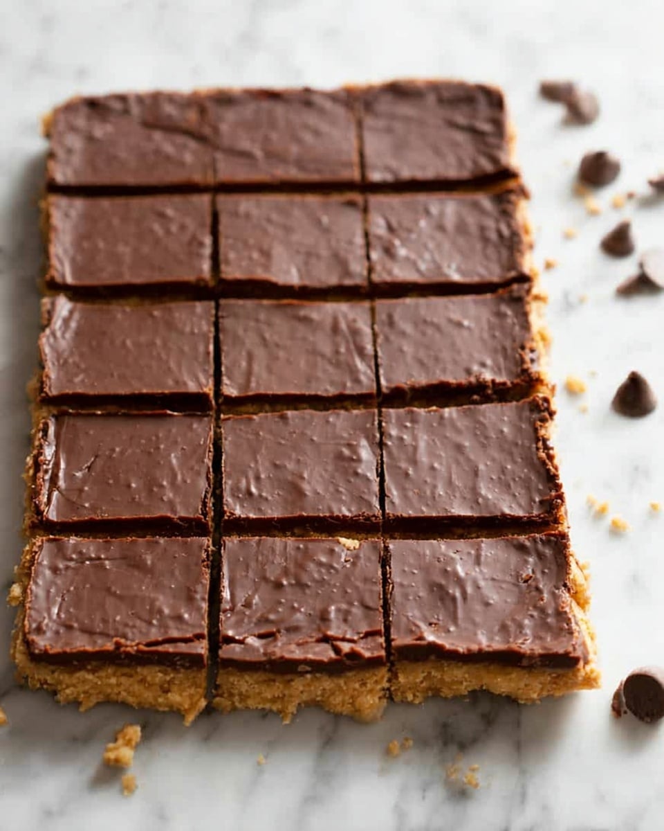 The image shows a stack of six thick bars arranged unevenly on a white plate with a textured edge. Each bar has two layers: the bottom layer is golden brown and crumbly with a rough texture, while the top layer is smooth and glossy dark brown chocolate. The bars are stacked in a way that some edges and crumbs are visible around them on the plate. The background is a soft white marbled surface, with a glass of milk slightly blurred in the back, adding a cozy and inviting feel. photo taken with an iphone --ar 4:5 --v 7
