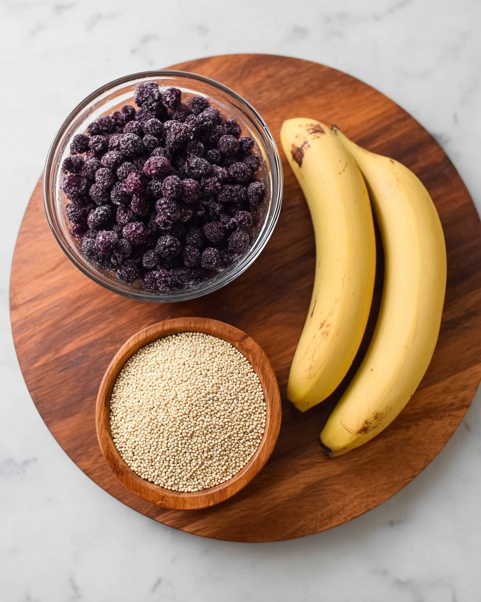 A round wooden board holds three ingredients on a white marbled surface: a clear glass bowl filled with many small frozen dark purple berries on the top left, a smaller wooden bowl full of light beige quinoa grains at the bottom center, and two yellow bananas with brown spots resting parallel to each other on the right side. The whole setup is simple and natural. photo taken with an iphone --ar 4:5 --v 7